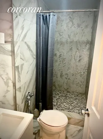 a bathroom with a toilet and a shower