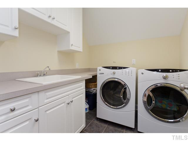 7613 Double E Court Raleigh, NC 27613 - Photo 20 of 23 Separate Laundry Room with lots of Cabinets, Utility Sink, & Tile Flooring. Laundry Room