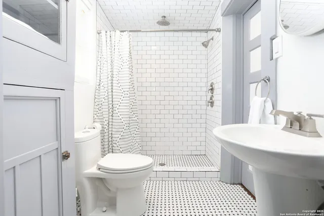 a bathroom with a sink a toilet and shower