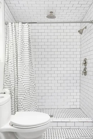 a bathroom with a toilet and a shower