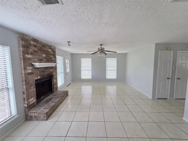 a view of empty room with a fireplace and fan