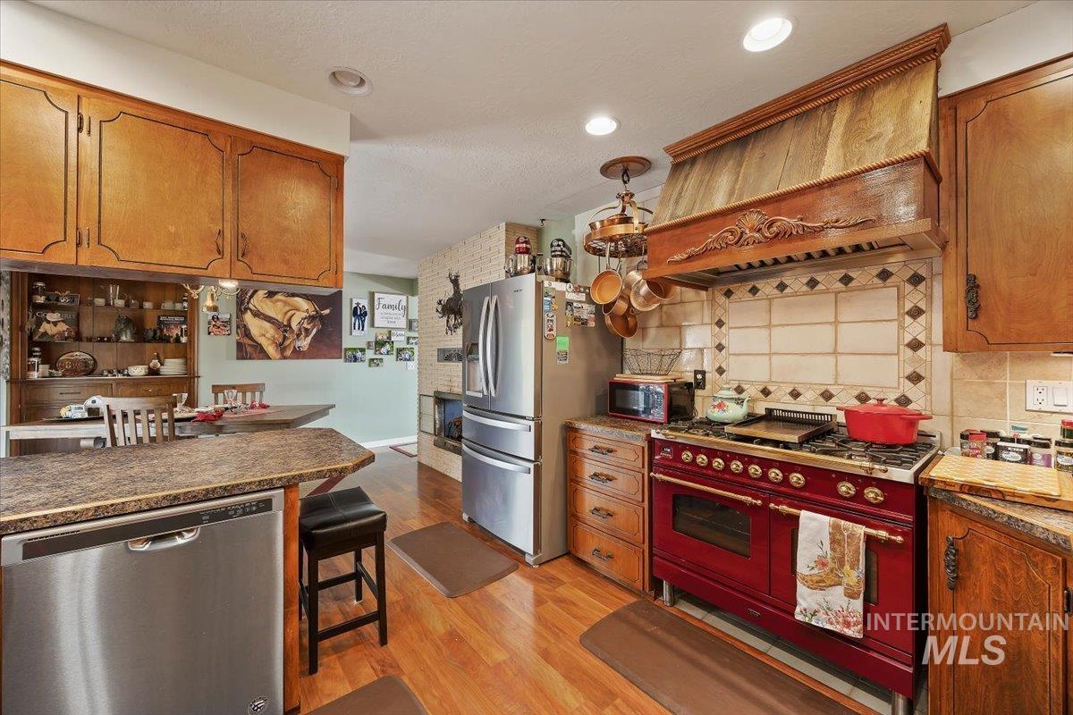1301 A Street Rupert, ID 83350 - Photo 16 of 45 Kitchen featuring wood finish cabinets, stainless steel appliances, tasteful backsplash, and light wood finished floors