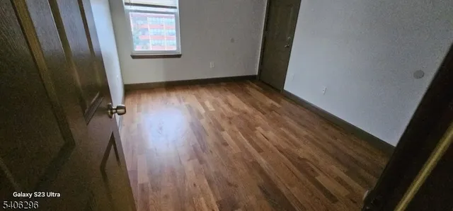 a view of a room with wooden floor and a window