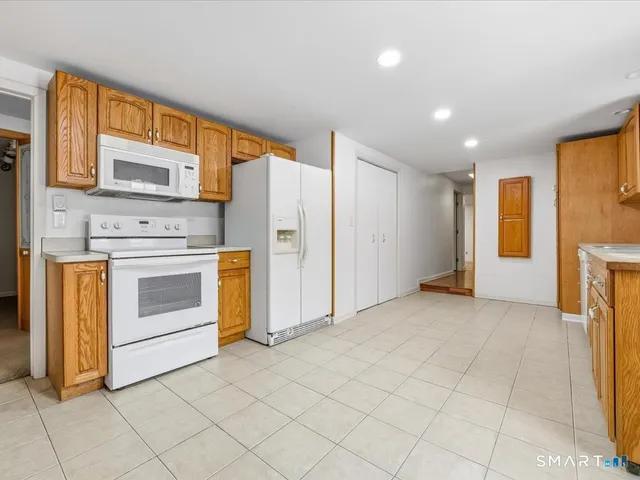 a view of a kitchen with furniture and a refrigerator