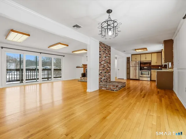 a view of a living room with kitchen island and wooden floor