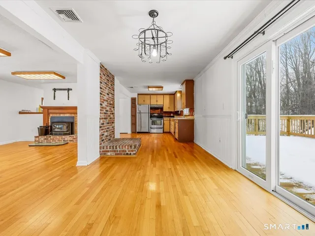 a view of empty room with a window and wooden floor