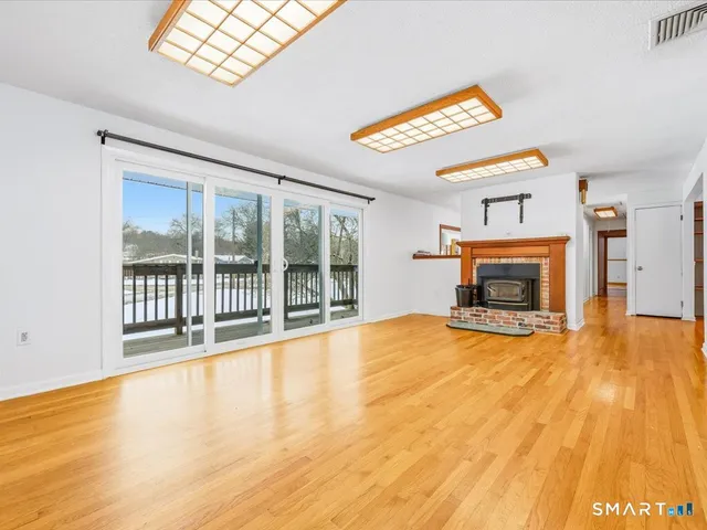 a view of an empty room with a fireplace and a window