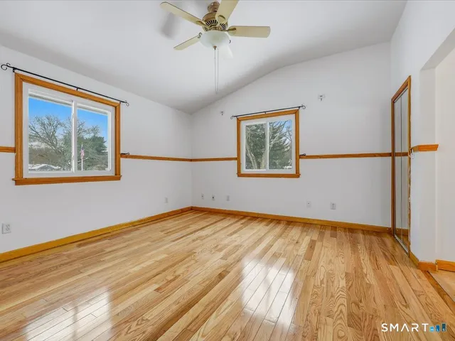 a view of empty room with wooden floor