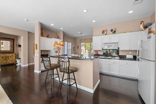 a kitchen with a table chairs refrigerator and cabinets