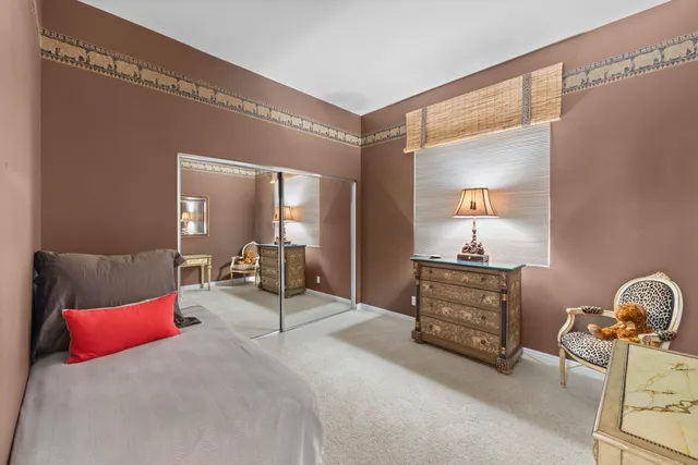 a bedroom with a bed and dresser with mirror