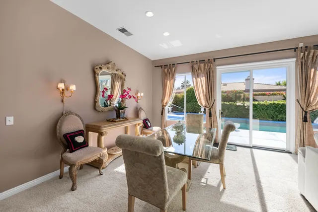 a living room with furniture a floor to ceiling window and potted plant