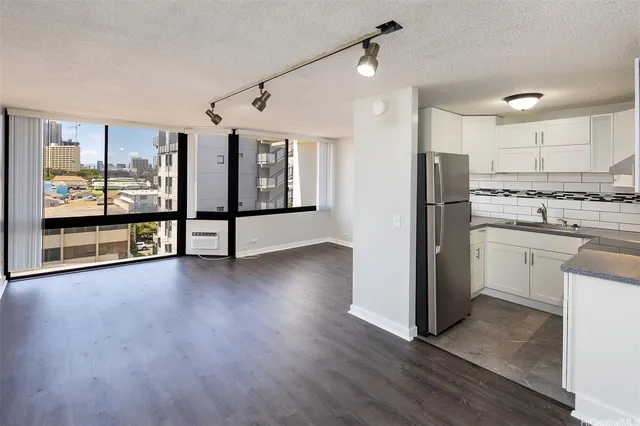 a view of a kitchen with refrigerator and wooden floor
