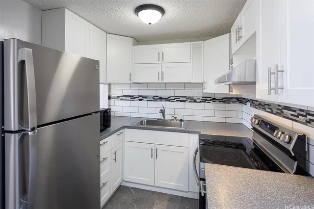 a kitchen with white cabinets and stainless steel appliances