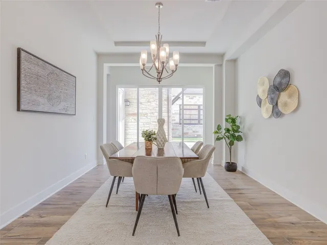 a view of a dining room with furniture a chandelier and wooden floor