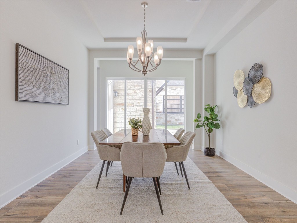 345 Two Creeks Lane Austin, TX 78737 - Photo 15 of 40 a view of a dining room with furniture a chandelier and wooden floor