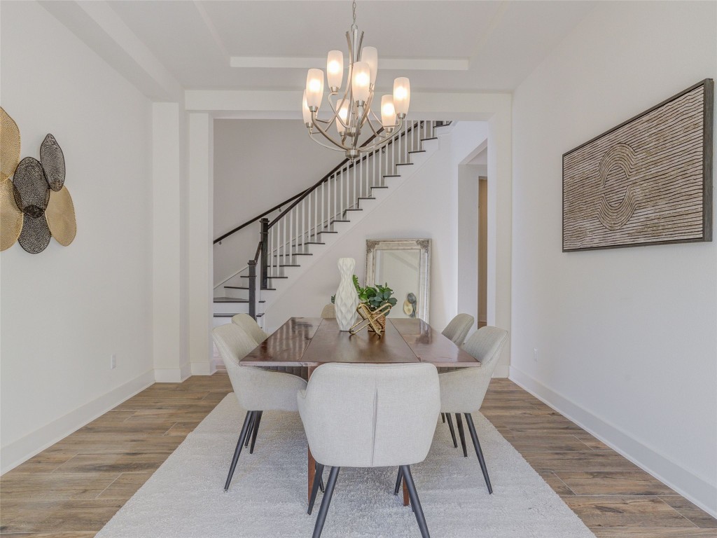 345 Two Creeks Lane Austin, TX 78737 - Photo 16 of 40 a dining room with wooden floor a chandelier a wooden table and chairs