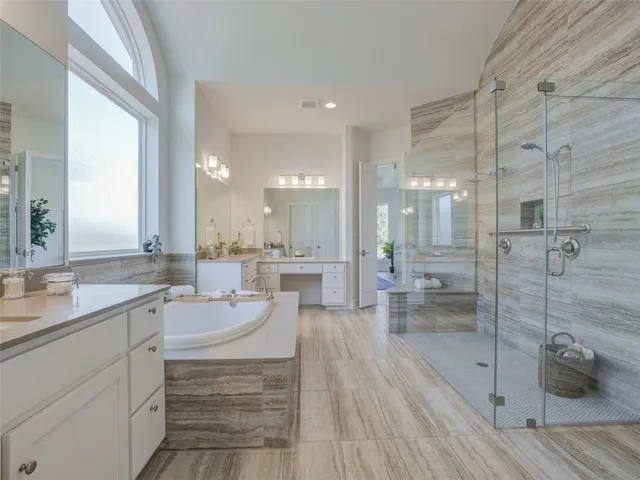 a bathroom with a sink a toilet a mirror and shower