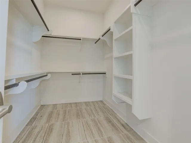 a view of walk in closet with empty racks