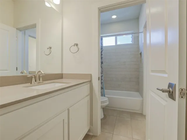 a bathroom with a granite countertop sink a toilet and shower