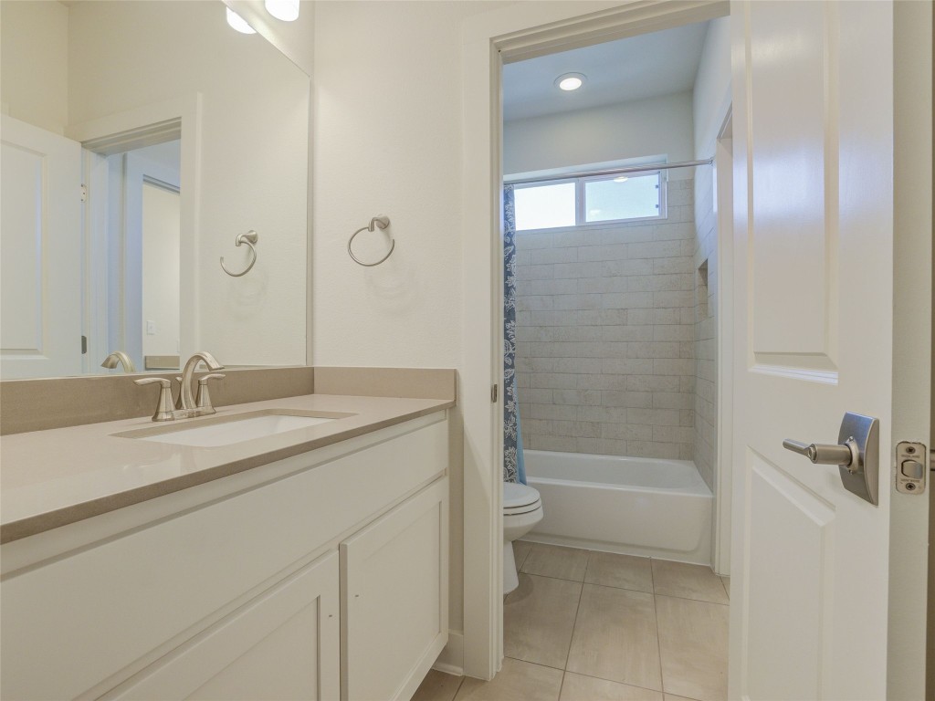 345 Two Creeks Lane Austin, TX 78737 - Photo 32 of 40 a bathroom with a granite countertop sink a toilet and shower