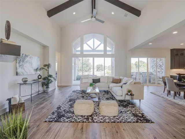 a living room with furniture large window and wooden floor