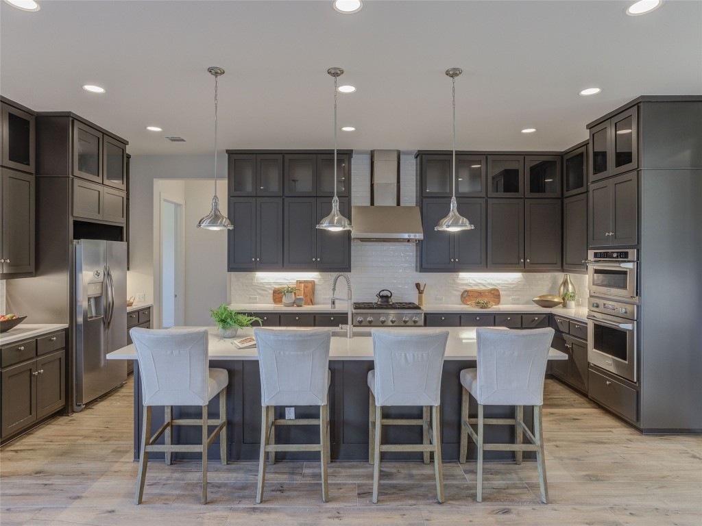 345 Two Creeks Lane Austin, TX 78737 - Photo 7 of 40 a kitchen with stainless steel appliances kitchen island granite countertop a kitchen island a stove and cabinets