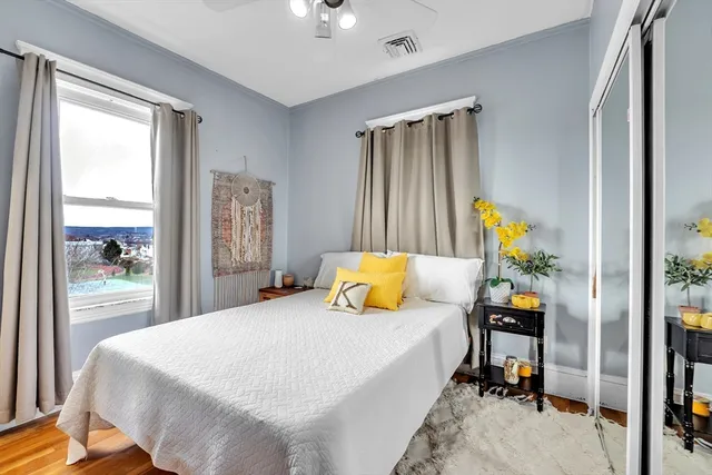 a bedroom with a bed and large window