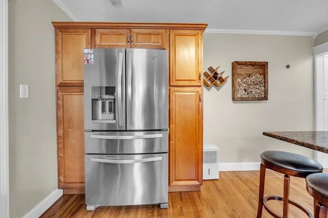 a kitchen with stainless steel appliances a refrigerator and wooden floor