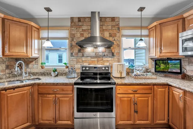 a kitchen with stainless steel appliances granite countertop a stove a sink and a granite counter tops
