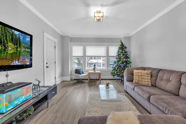 a living room with furniture flat screen tv and a window