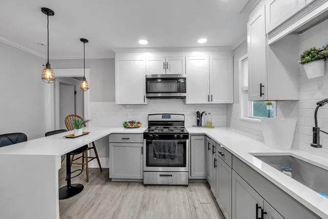 a kitchen with a sink a counter top space stainless steel appliances and cabinets