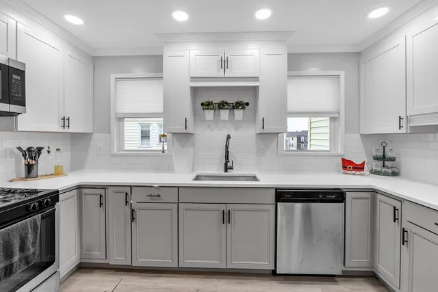a kitchen with white cabinets stainless steel appliances and sink