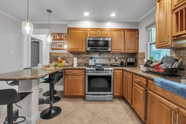 a kitchen with stainless steel appliances granite countertop a stove top oven a sink a counter space and cabinets