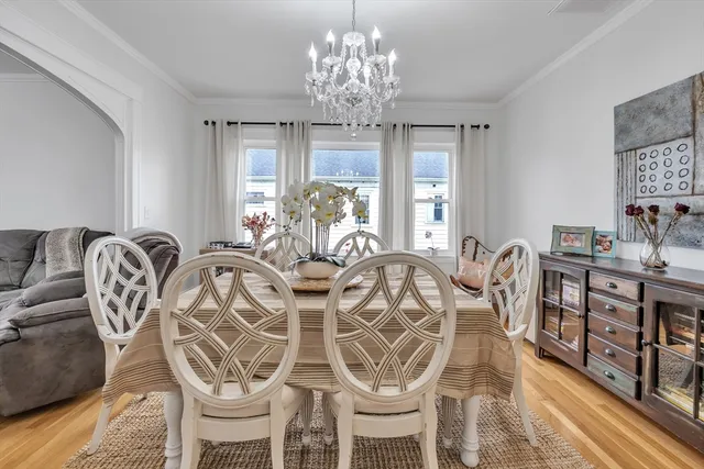 a view of a dining room with furniture a chandelier and wooden floor
