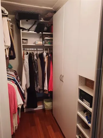 a view of walk in closet with clothes and shoes