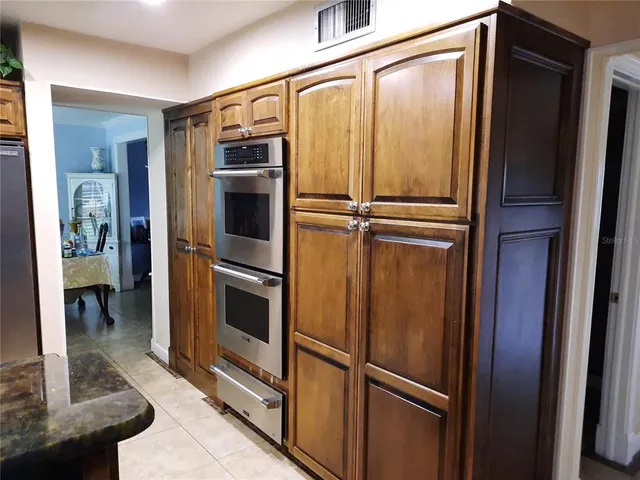 a view of a refrigerator in kitchen and a window