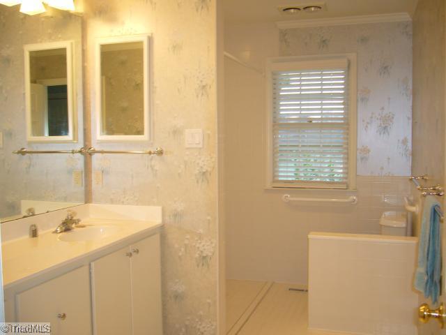 4500 Oakcliffe Road Greensboro, NC 27406 - Photo 10 of 11 Master Bath/Spa. Master bath has several special features for ease of use: low-threshhold shower access, removable storage units below sinks for HC access if ever needed, tall commode, tile floors, large wall mirror!
