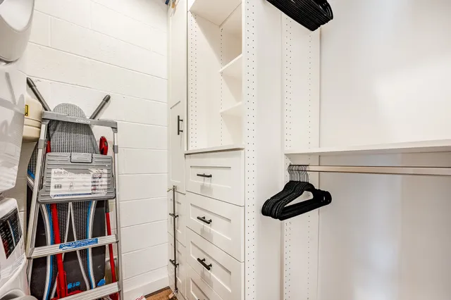 a view of walk in closet with clothes and shoes