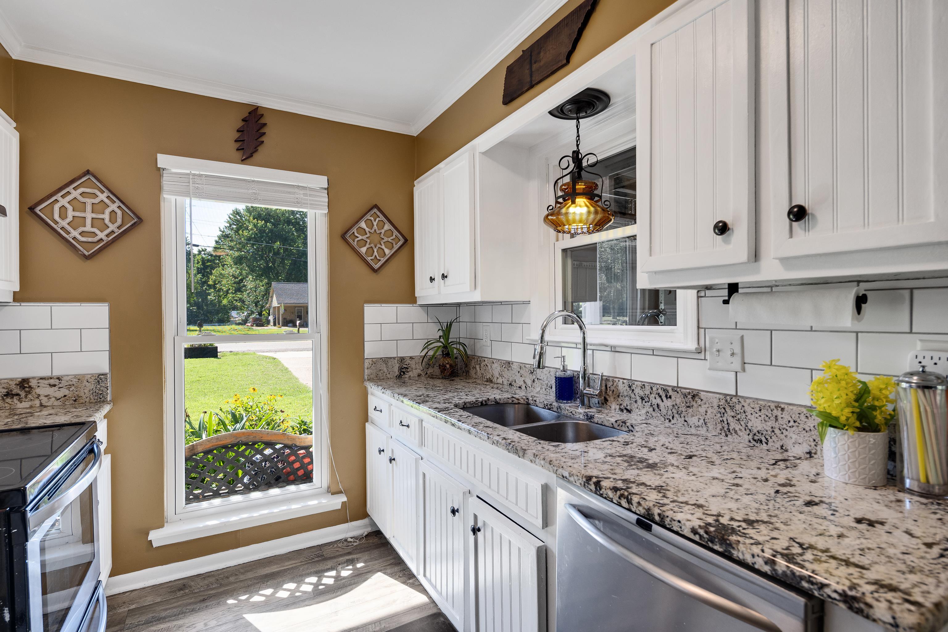 2399 Beaver Road Munford, TN 38058 - Photo 12 of 31 Kitchen featuring white cabinetry, granite-style countertops, subway tile backsplash, stainless steel appliances