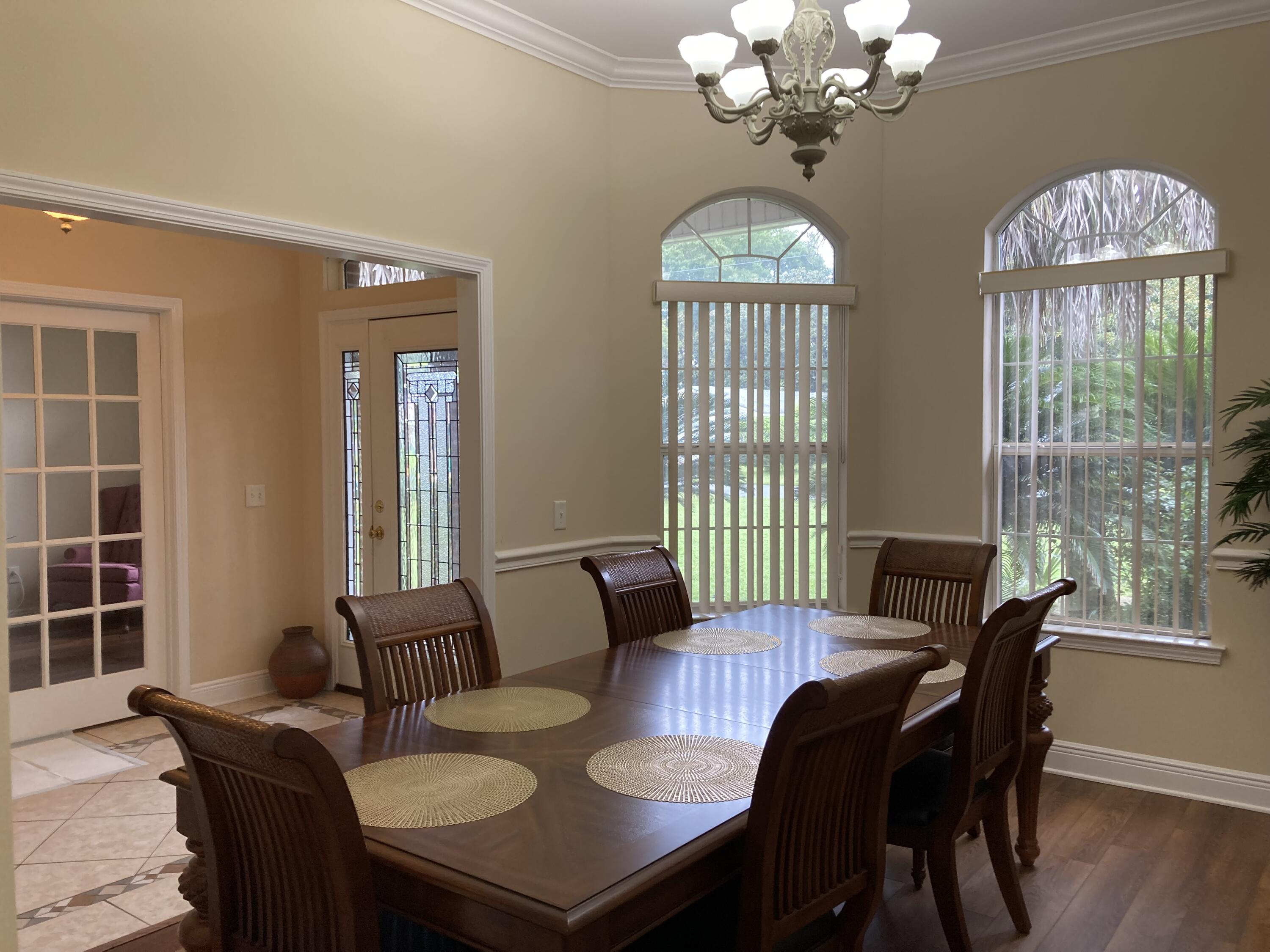 10 Maple Avenue Shalimar, FL 32579 - Photo 6 of 21 a view of a dining room with furniture a chandelier and wooden floor