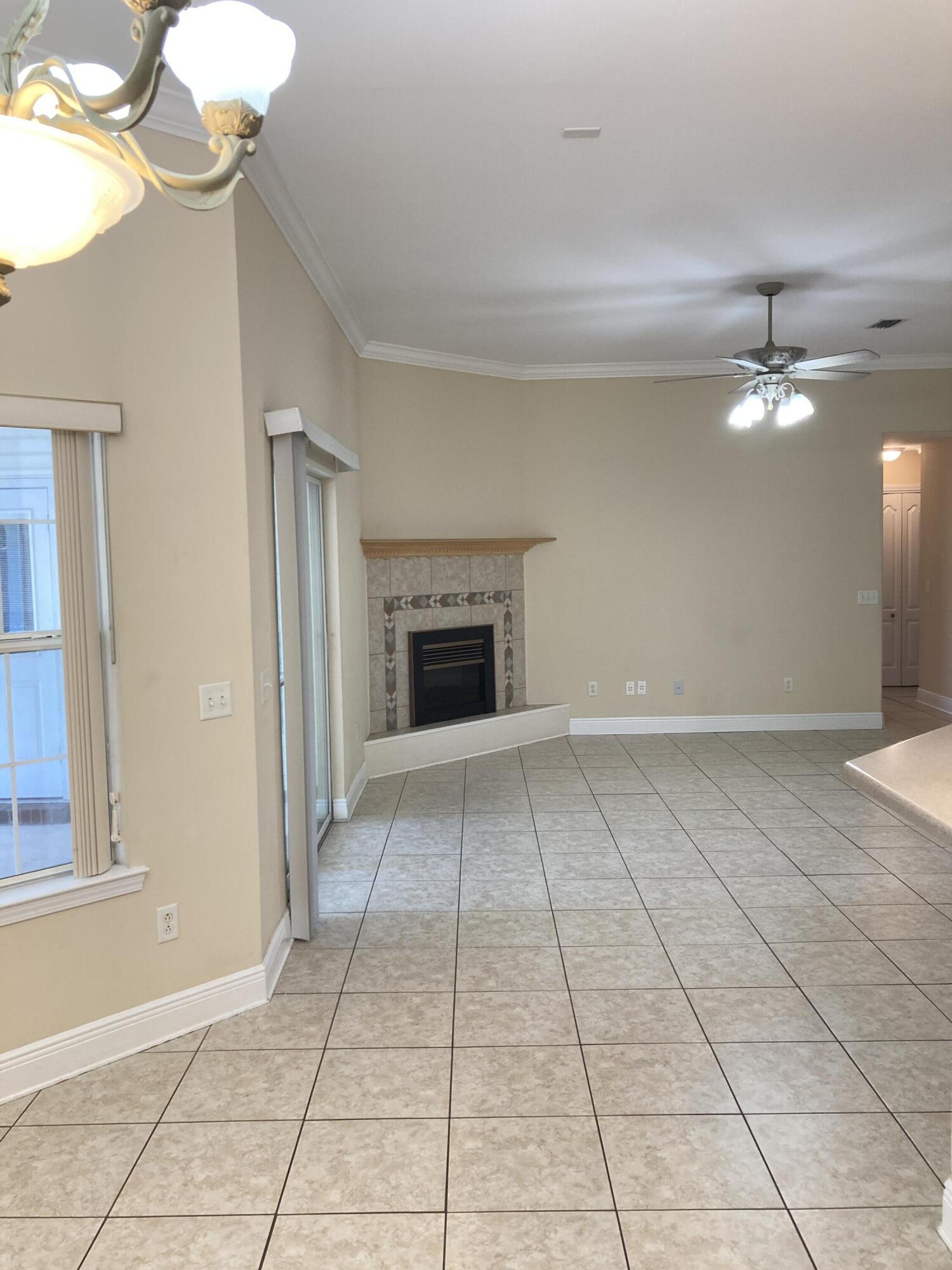 10 Maple Avenue Shalimar, FL 32579 - Photo 10 of 21 a view of an empty room with chandelier fan and fire place