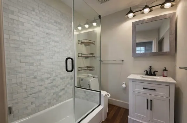 a bathroom with a shower sink and mirror