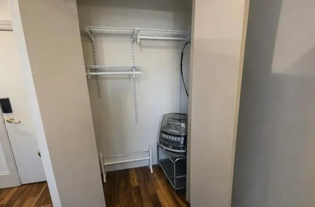 a view of closet with wooden floor