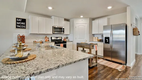 a kitchen with kitchen island granite countertop a sink stove and refrigerator