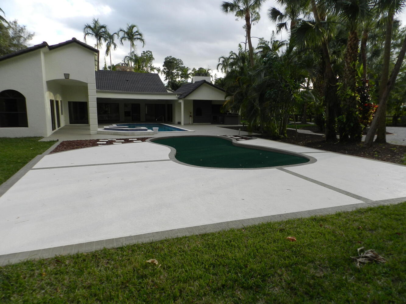 12677 Pineacre Lane Wellington, FL 33414 - Photo 13 of 38 a view of a white house with a yard and potted plants