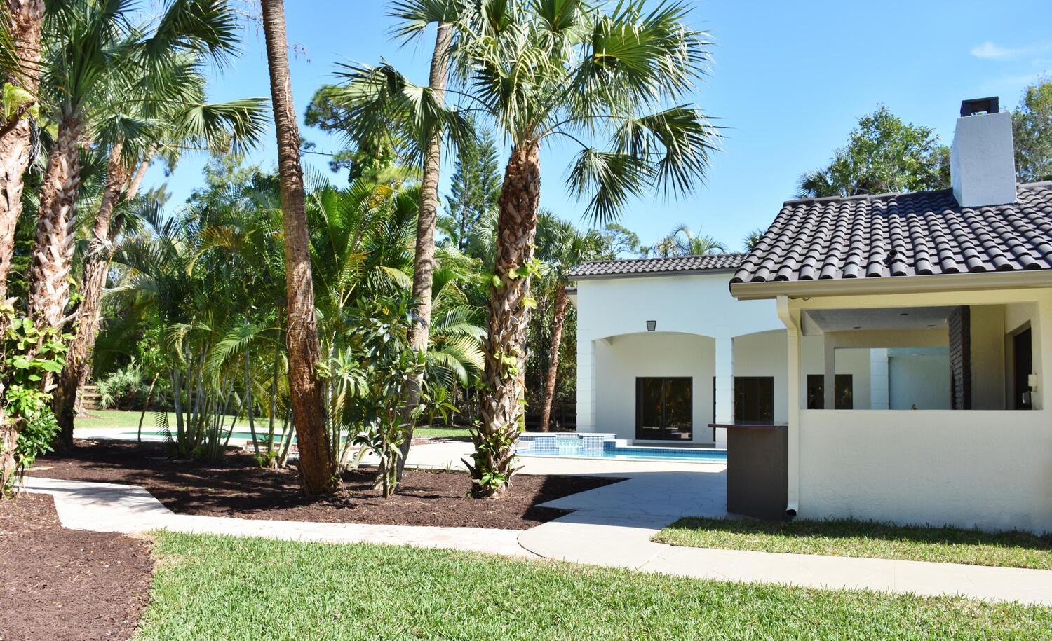 12677 Pineacre Lane Wellington, FL 33414 - Photo 18 of 38 a front view of a house with garden