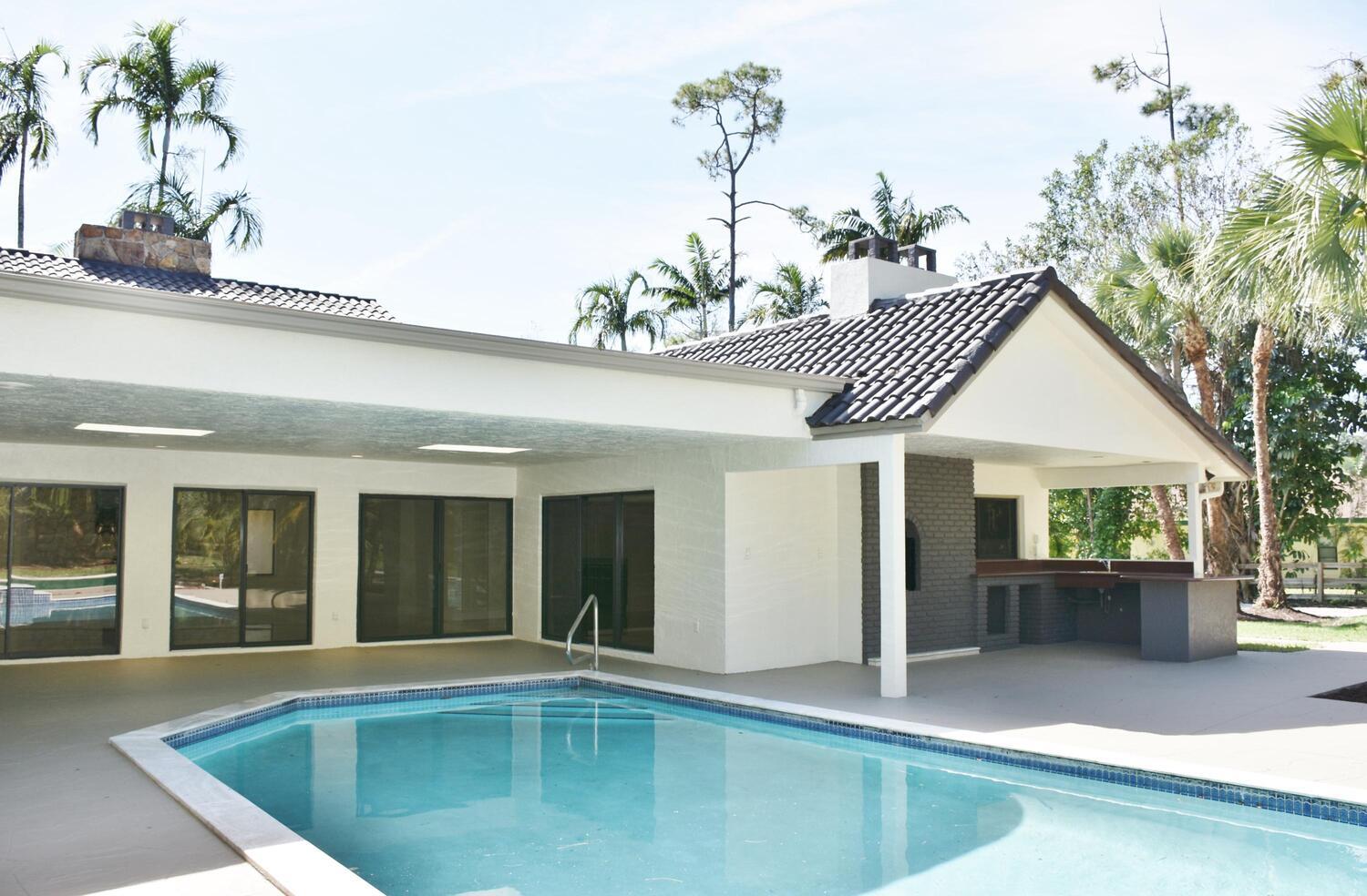12677 Pineacre Lane Wellington, FL 33414 - Photo 22 of 38 a view of a house with a swimming pool and sitting area