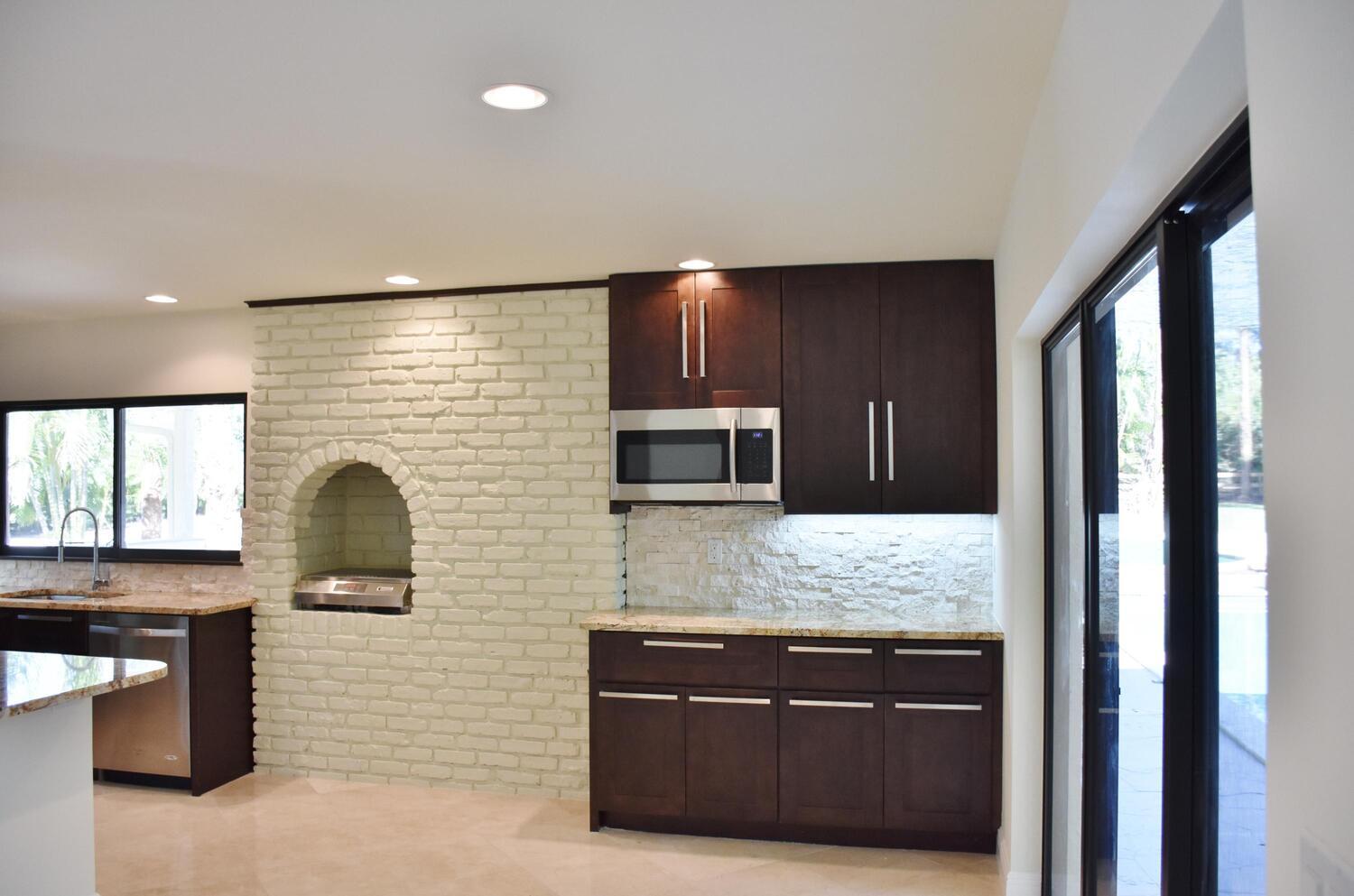 12677 Pineacre Lane Wellington, FL 33414 - Photo 3 of 38 a kitchen with stainless steel appliances granite countertop a stove a sink and a microwave