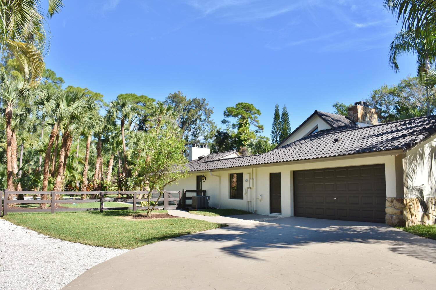12677 Pineacre Lane Wellington, FL 33414 - Photo 8 of 38 a view of a house with a yard and potted plants