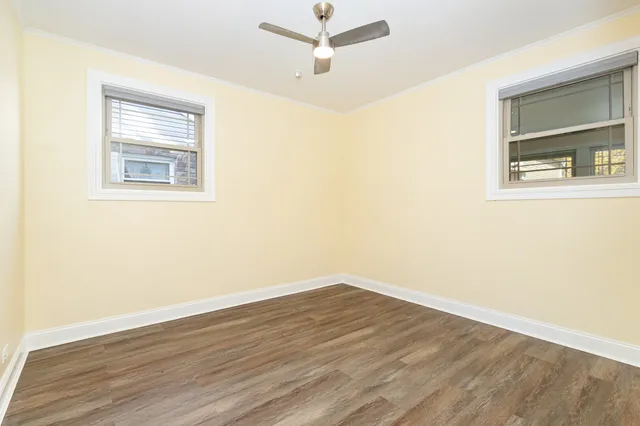 an empty room with a window and a ceiling fan